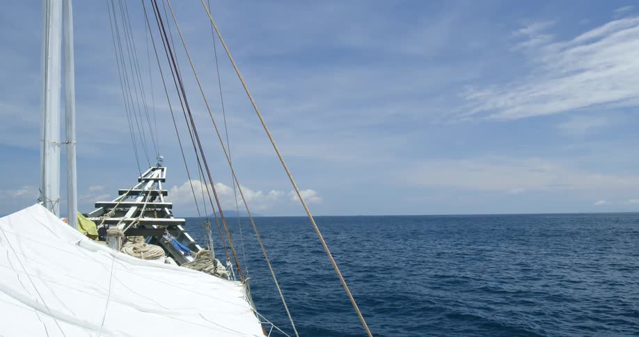 The bow of a ship as it travels on the ocean on a sunny day