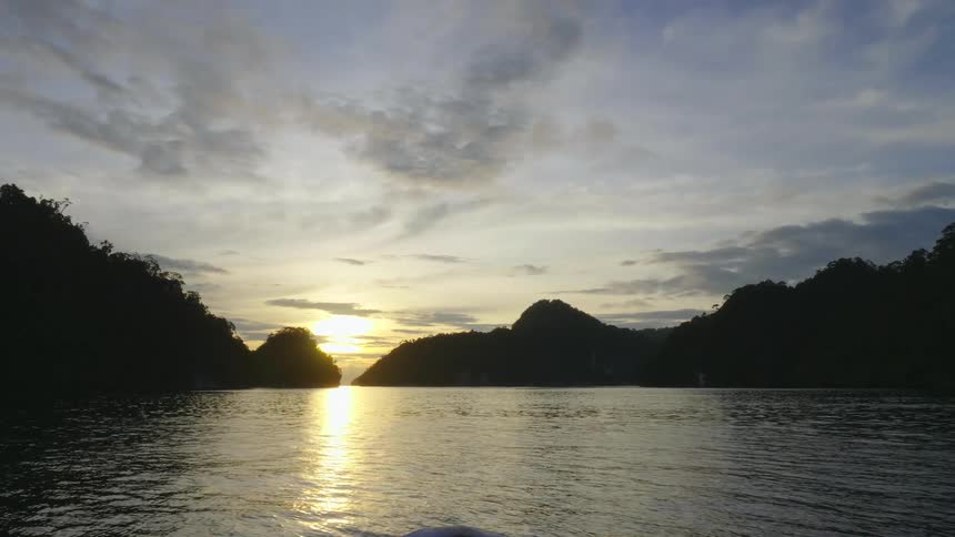 The sun is setting in the horizon above the water