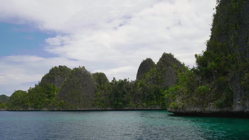 Turquoise ocean water rippling around a tropical island in the daytime