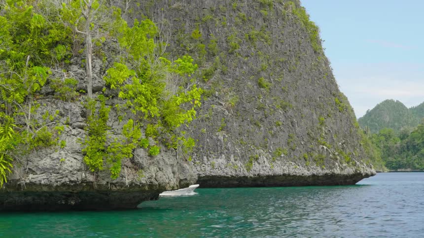 People boating off a coastline on turquoise water