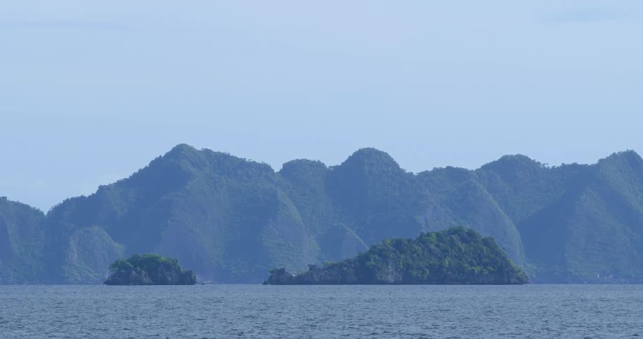 Ocean water flowing in front of a tropical island in the daytime