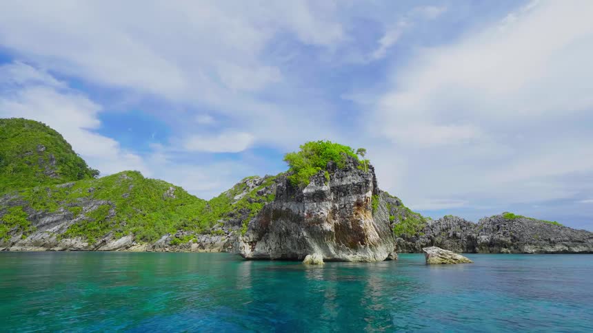 Turquoise ocean water rippling around a tropical island in the daytime