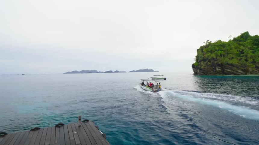 A group of people sail on a boat from a nearby dock