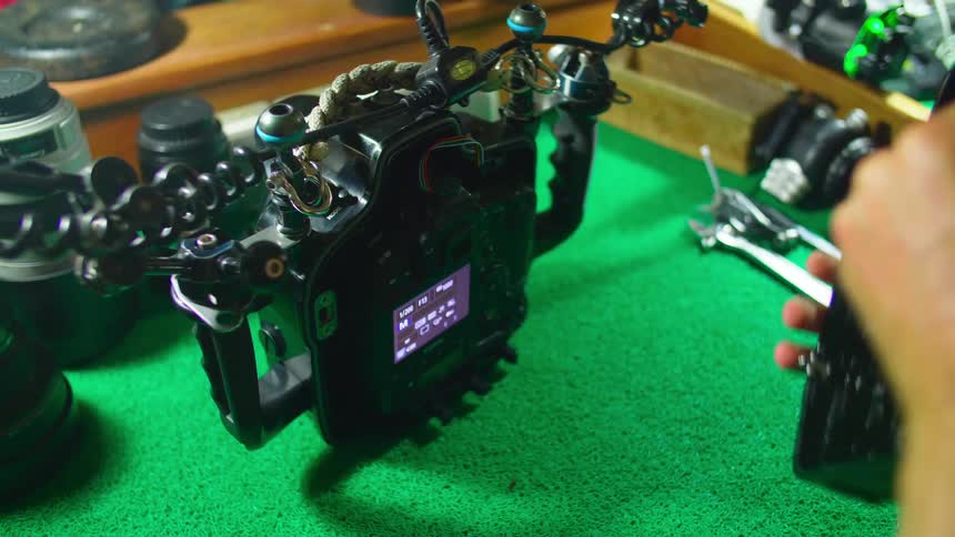 A woman repairs and camera and puts it back together