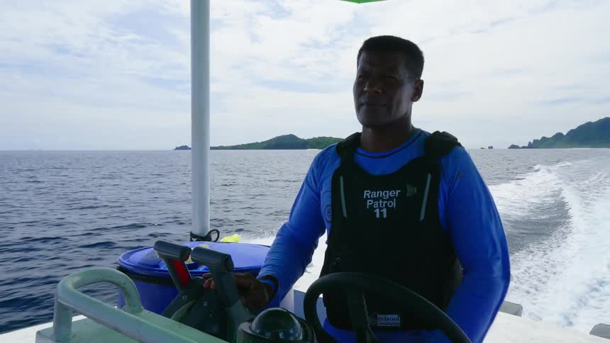 A ranger driving a patrol boat in the ocean