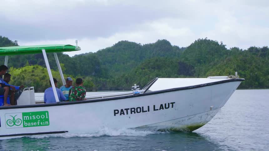 Water patrol officers ride on a speedboat as it sails through the ocean