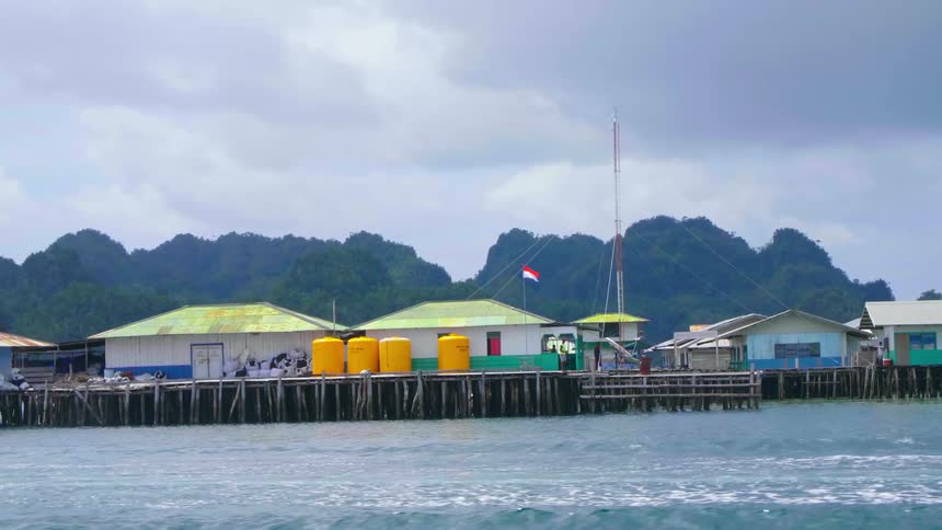 People walk on a dock with buildings on it