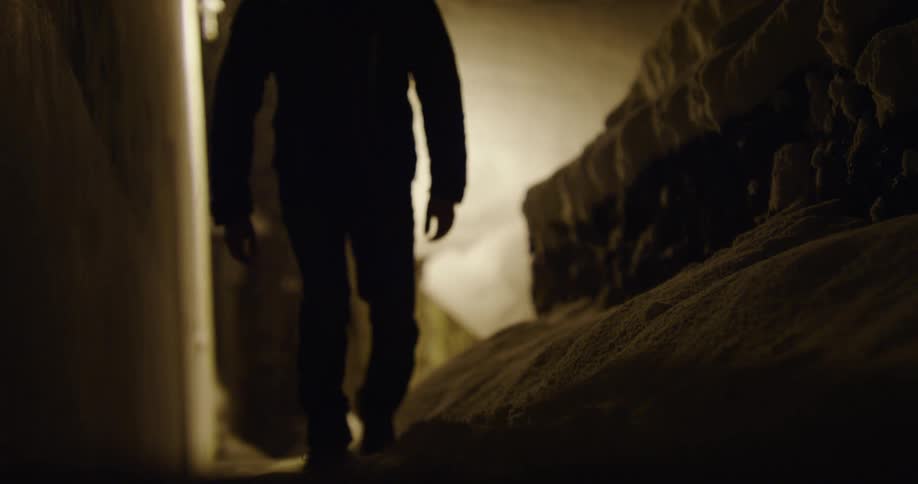 Man walks in snowstorm under streetlight at night