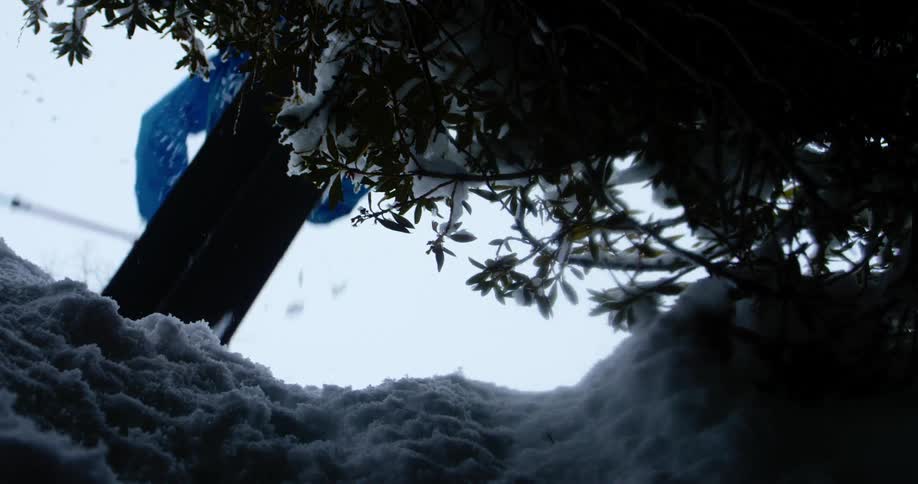 A skier going over a jump and landing in powdery snow