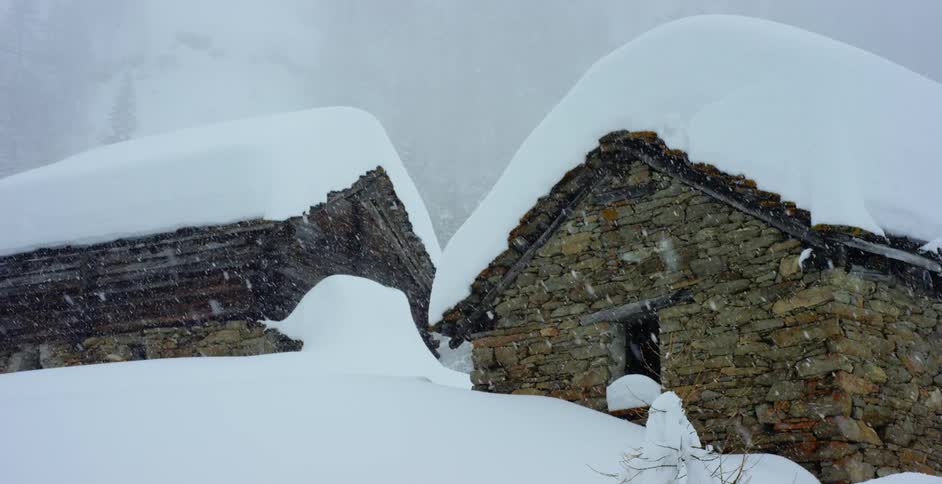 Snow falling onto two brick houses