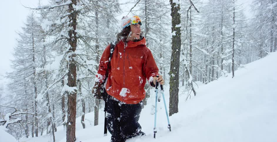 A man laughs as he stands knee deep in snow on a hill