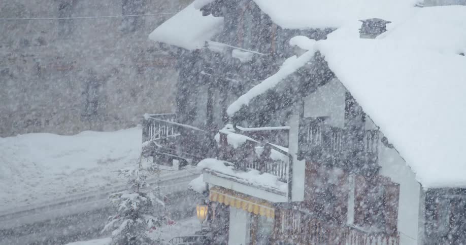 A car is driving through a neighborhood in winter