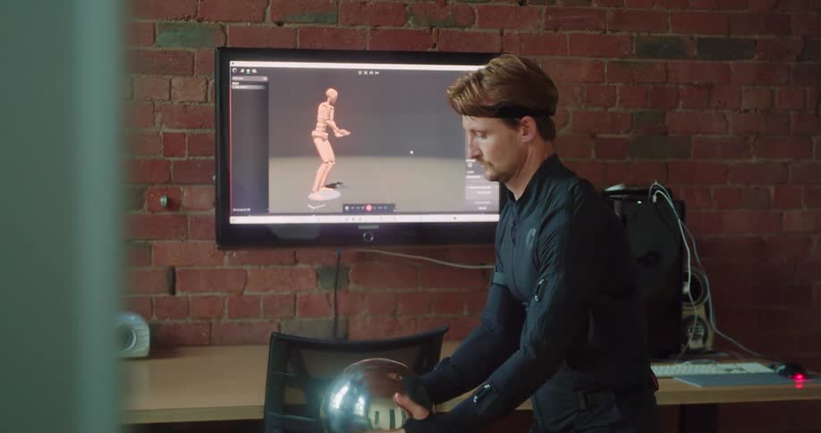 Man lifts ball capturing motion shown on display positioned against brick wall