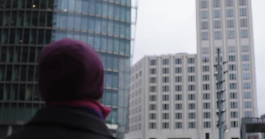 A man is standing in a downtown city