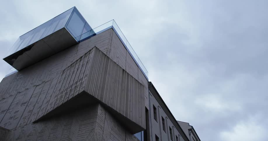 A glass atrium sits on top of a building with an angular design
