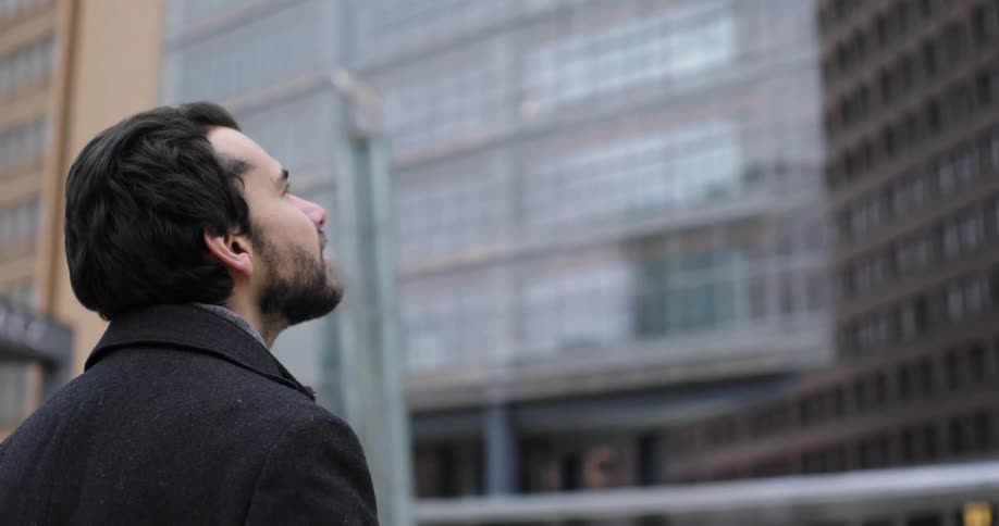 A man is standing outdoors in an urban city