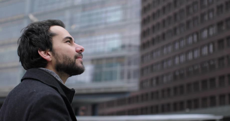 A man is standing outdoors in a downtown city