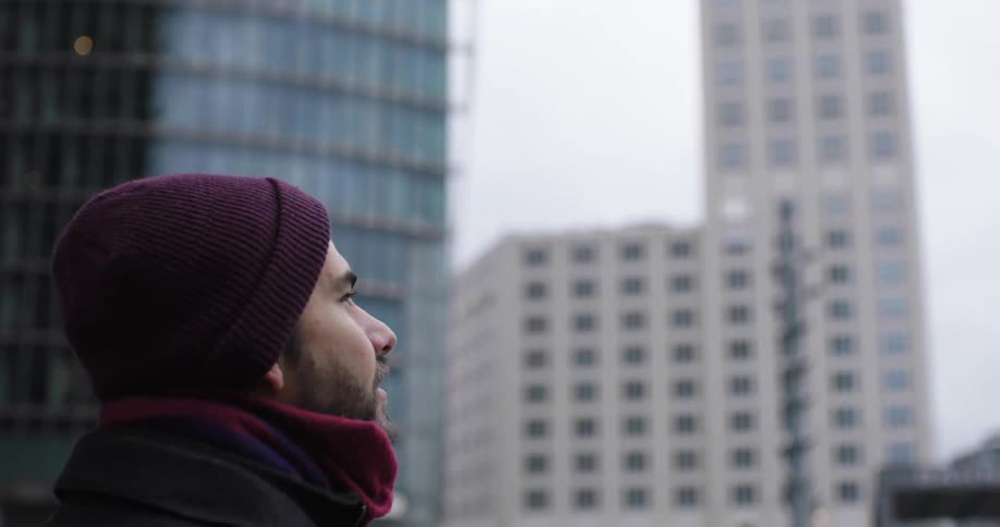 A man is walking outdoors in the city
