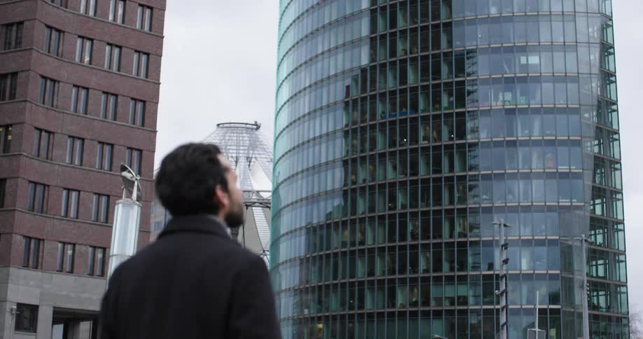 A man is standing outdoors in a big city
