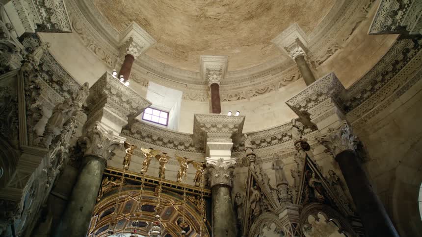 Columns stretch up toward high ceiling in ornate room of reliefs statues and inlays