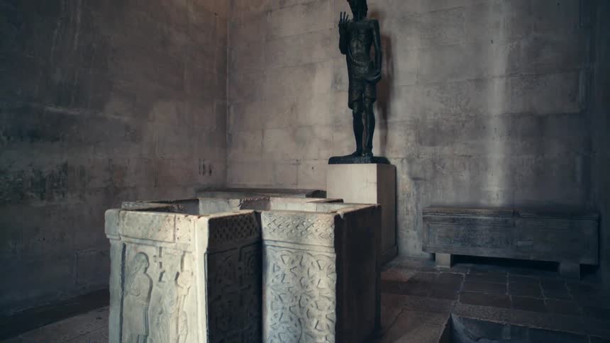 A stone room has carvings and a statue