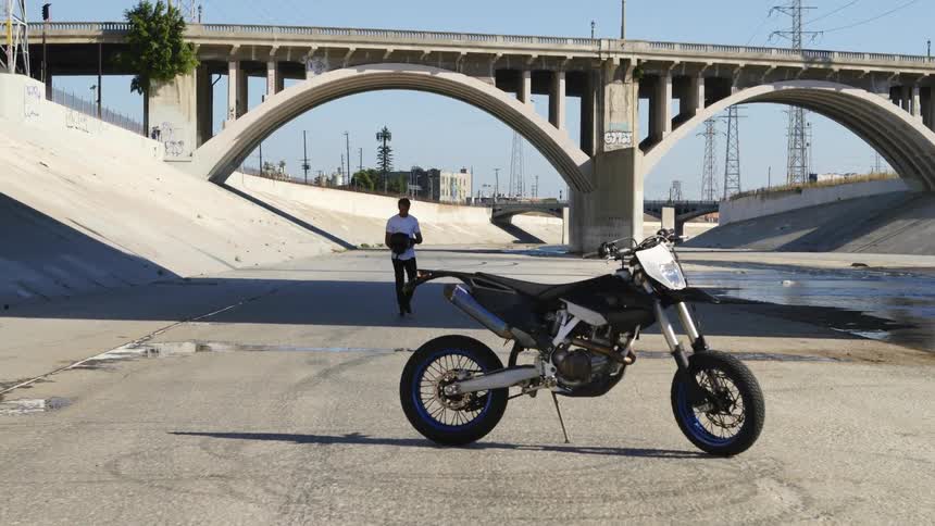 A man is walking towards his motorcycle during the day