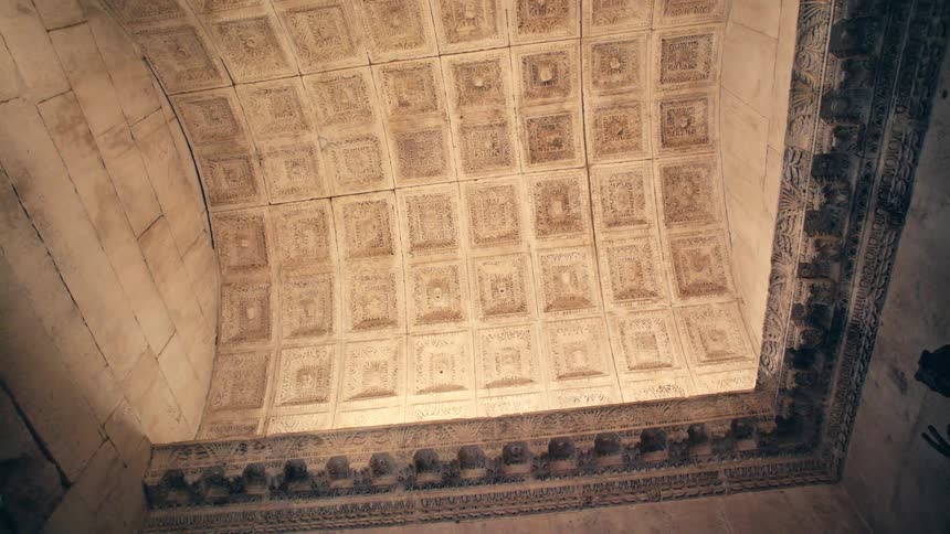 Carvings in a grid format fill a dome cutout in the ceiling at a museum