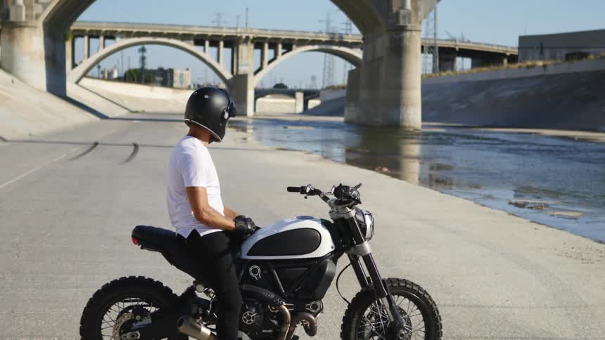 A man is sitting on a parked motorcycle