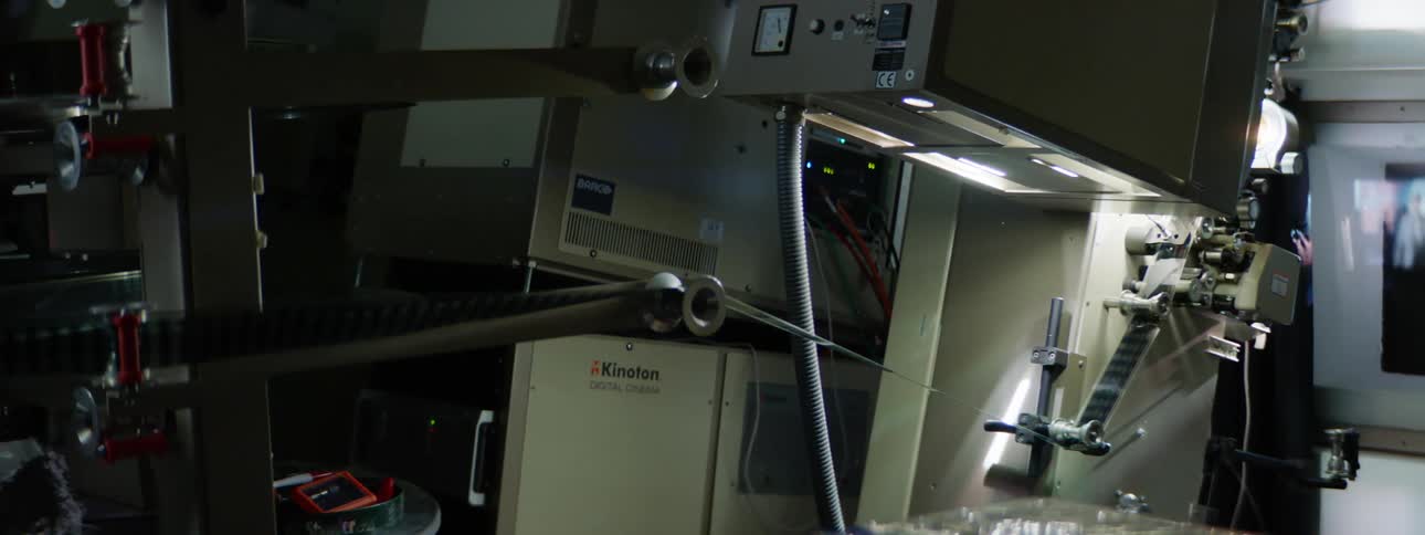 Filmstrip runs through machinery as video is displayed on small screen