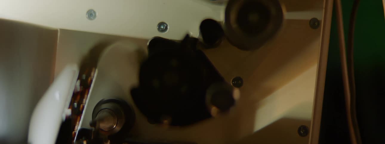 A film projector with a reel of tape running in the machine