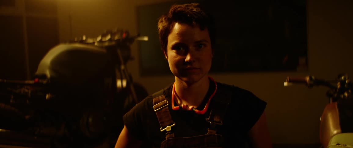 A woman is smiling inside a room at night