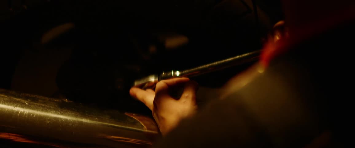 A mechanic tightens a bolt on a vehicle