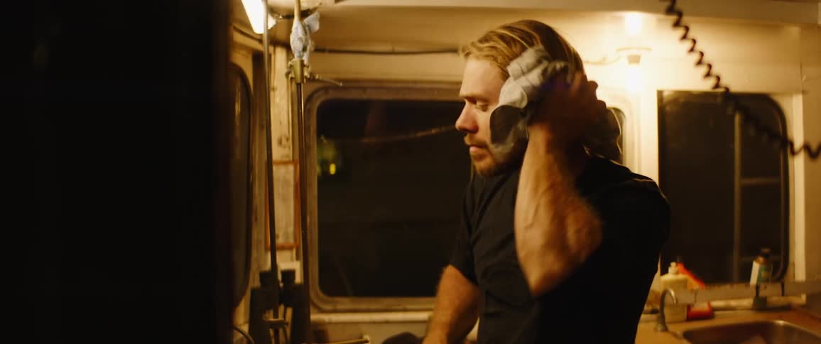 A man cleans up in the boat cabin