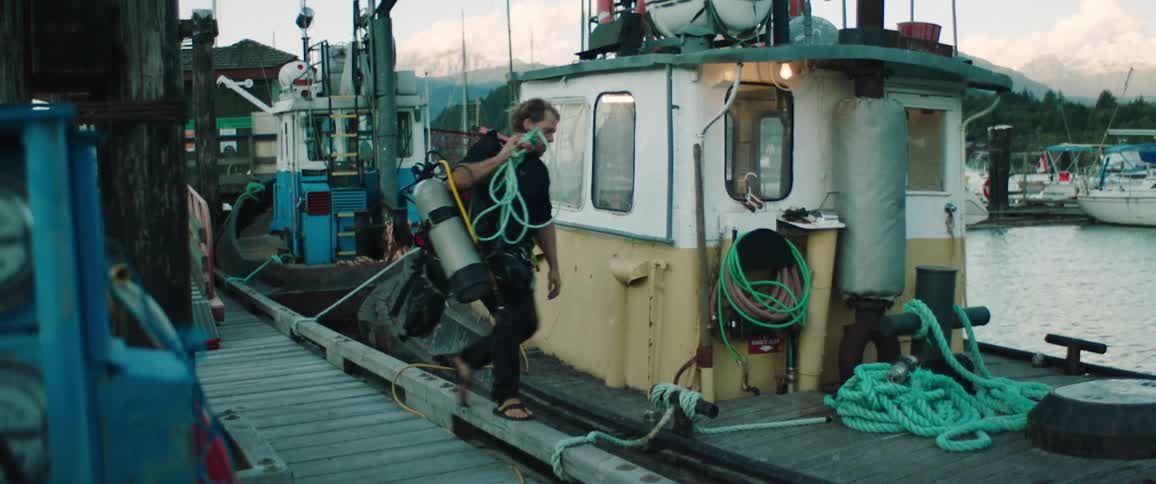 A man carries equipment onto the boat