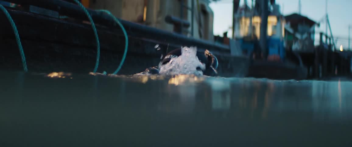 A diver lowers his head under the water