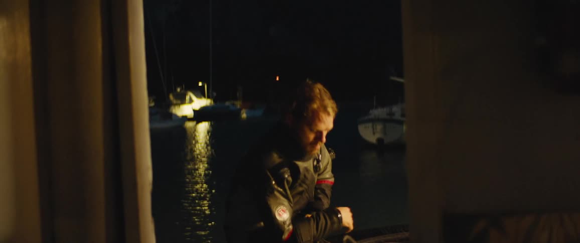 A man takes his oxygen tank off his back after scuba diving