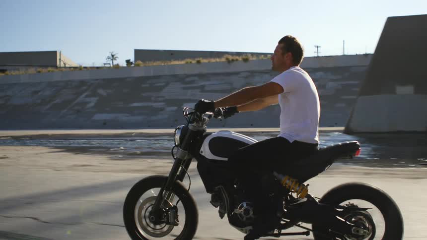 A male driving a motorcycle on a road