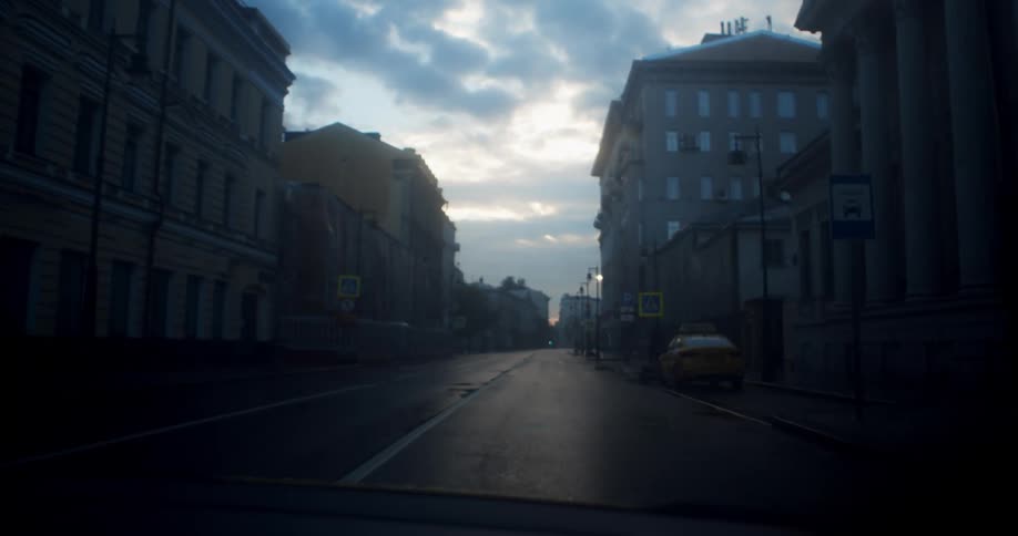 A car drives down a quiet city street