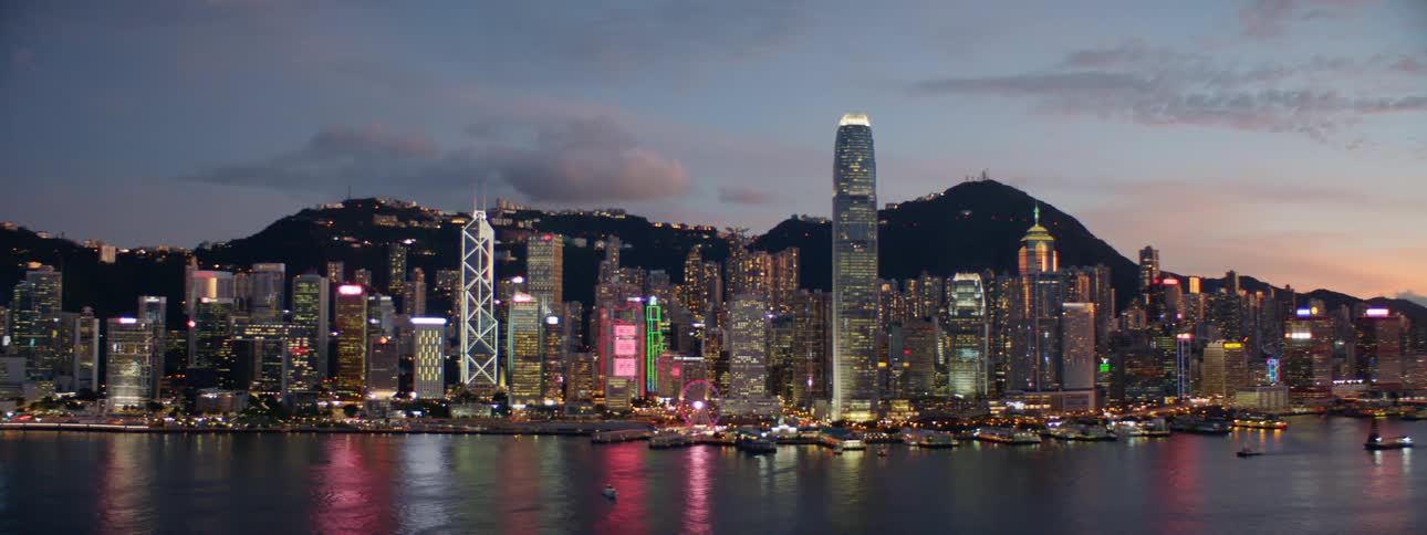City skyscrapers and lights reflecting on a body of water at dusk