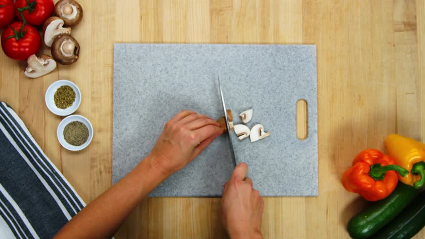 A person is cutting food on a cutting board