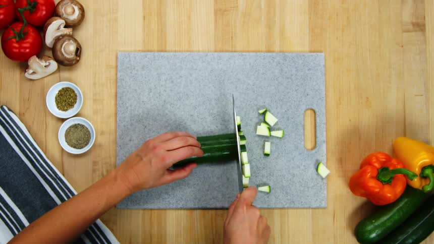 A person is cutting a cucumber with a knife