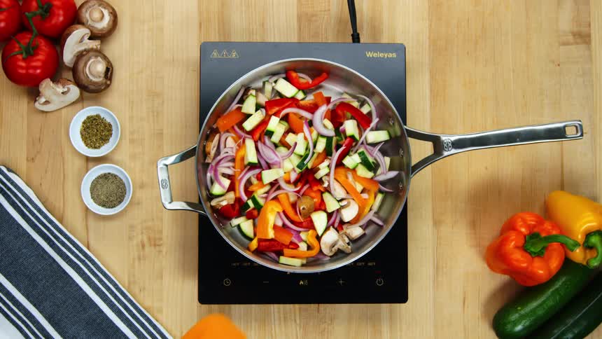 A person stirring vegetables in a pan