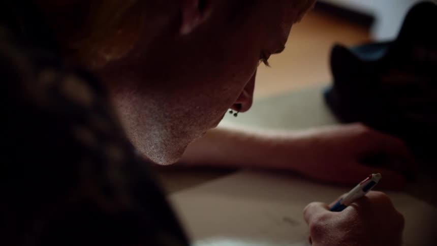 A teenager sits and draws a picture