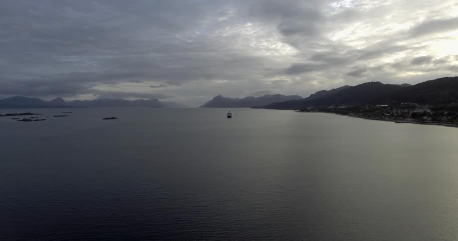 Lake with a boat out in the distance on cloudy evening