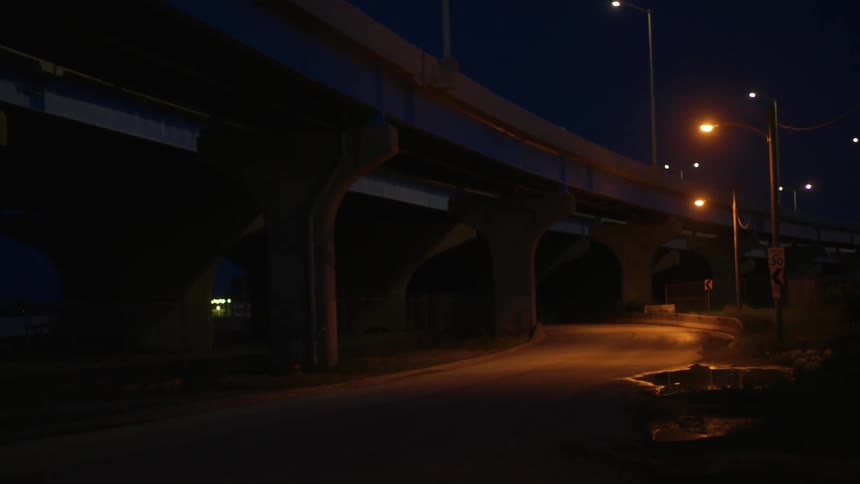 A city with an overpass streetlights and streets