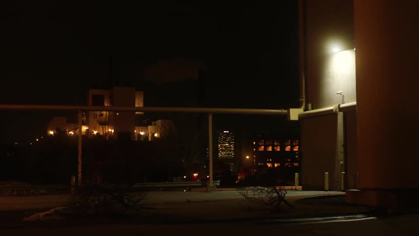 A business parking lot is empty and lit up at night