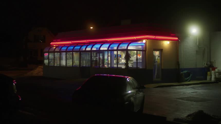 Cars parked outside a restaurant in a city