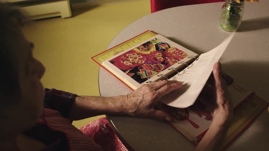 A woman is looking through a recipe book