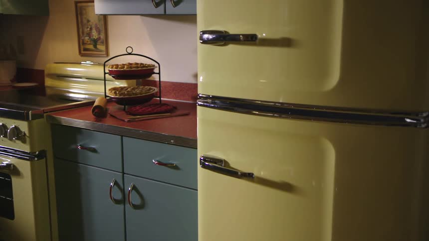 A person reaches to open the fridge