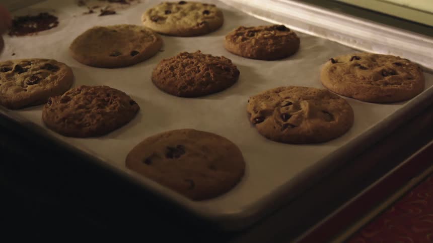 A woman is baking cookies in the kitchen